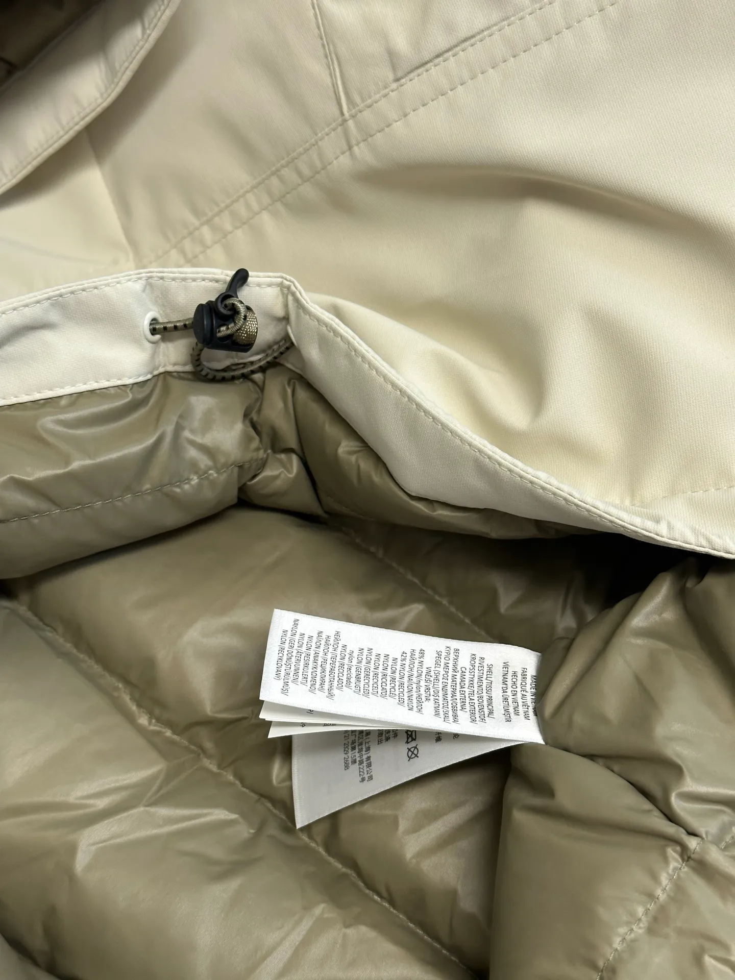 P970 Ralph Lauren logo hooded down jacket. The density of high-density nylon taffeta is about 210T-300T. The surface is smooth and slightly matte. It has excellent windproof and waterproof performance (with DWR water-repellent treatment). It has strong wrinkle resistance and is easy to care for. It is in line with the positioning of American casual "durable and practical".  The inner lining is made of 100% polyamide. The high-density and tight weaving process prevents fine lint from getting out of the gaps in the fabric. The smooth surface improves the putting on and taking off experience, and the excellent wear and tear resistance ensures damage caused by frequent use, while the light and soft texture does not affect the overall weight.  It uses 90 white duck down with a weight of 220g to ensure excellent thermal insulation performance. After strict screening and processing, the velvet is not easily drilled, ensuring durability. The classic jacket has a slightly loose fit, with slightly dropped shoulder lines (the shoulder width is 1-2cm wider than the standard fit). The length reaches the hips, and the sleeves are slightly tapered straight sleeves, taking into account freedom of movement and casual style.  The adjustable Velcro on the cuffs allows you to freely adjust the tightness according to the thickness of your wrist and personal preferences, effectively preventing cold wind from intruding, and improving the warmth performance. Two zippered pockets on the front are convenient for placing frequently used items, and the zipper design ensures that items are not easily lost. A built-in pocket on the left side of the chest provides a safe storage space for some small private items.  The drawstring design at the hem allows you to adjust the shape of the jacket according to your body shape and dressing needs. Whether it is loose and casual or slim and neat, you can easily control it.  Polo horse logo on the left chest: flat satin stitch embroidery (satin embroidery), using 100% polyester high color fastness embroidery thread (the color number is consistent with the brand's standard red color card), the stitch density is 12-15 stitches/cm, the outline of the horse logo is clear, and the details of the rider and horse are burr-free. Precise positioning through the template (12cm from the bottom of the collar and 8cm from the placket) ensures symmetry and centering.  size：s m l xl